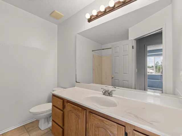 Bathroom featuring a wood-finish vanity with an integrated sink and a large mirror