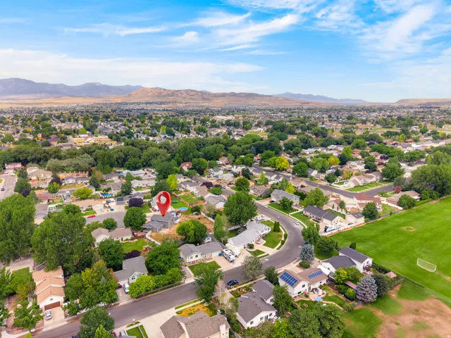 Expansive aerial perspective showcasing a residential neighborhood with a mountain backdrop