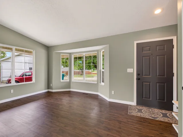 Open living space featuring wood-finish flooring, light grey walls, and white trim