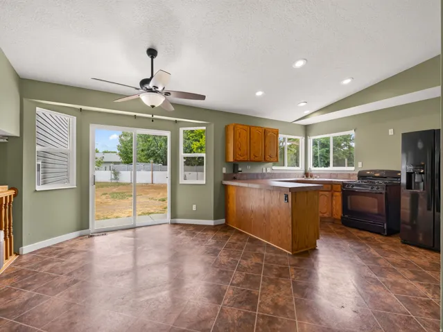 Spacious kitchen and dining area with tile flooring and a ceiling fan