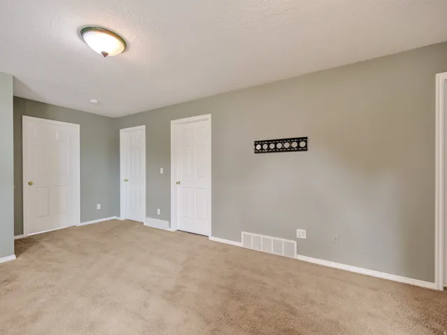 Carpeted interior room featuring neutral wall paint and white trim