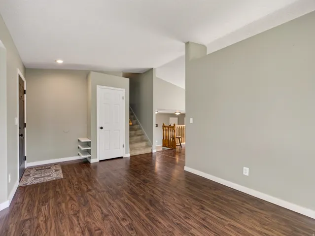 Entryway featuring wood-finish flooring, a white paneled interior door, and a dark exterior door