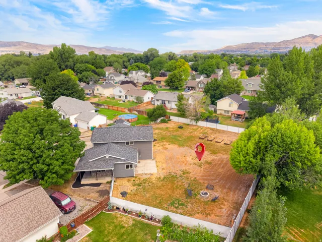 Expansive backyard featuring a fire pit area, garden beds, and mountain scenery
