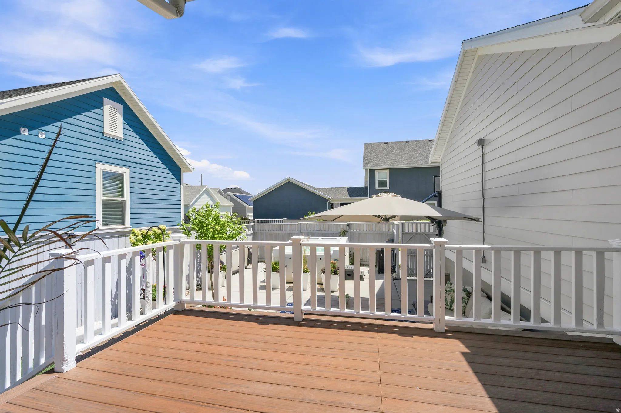 Expansive outdoor deck featuring wood-finish flooring and white perimeter railing