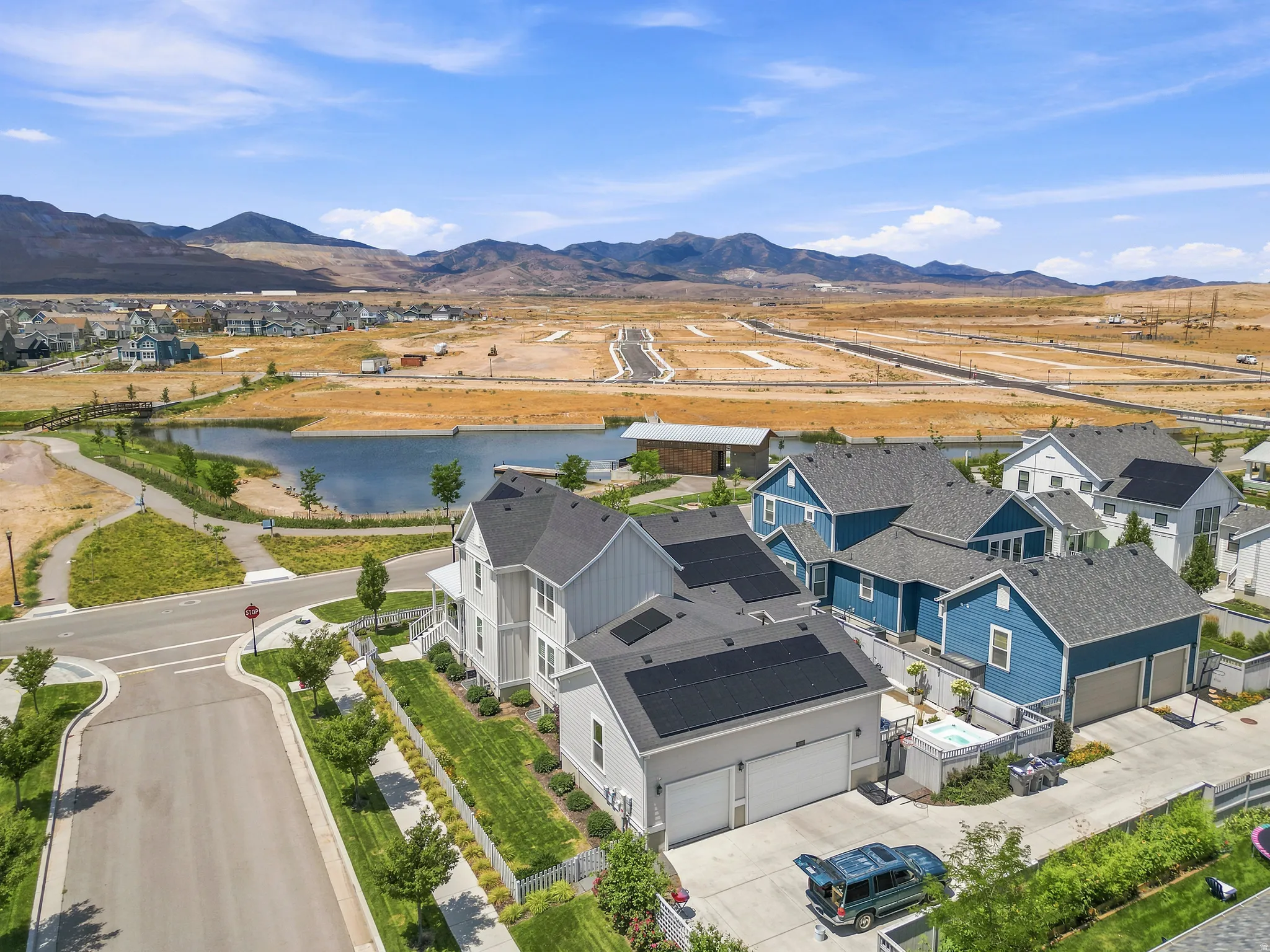 Modern residential development featuring a community lake and mountain backdrop