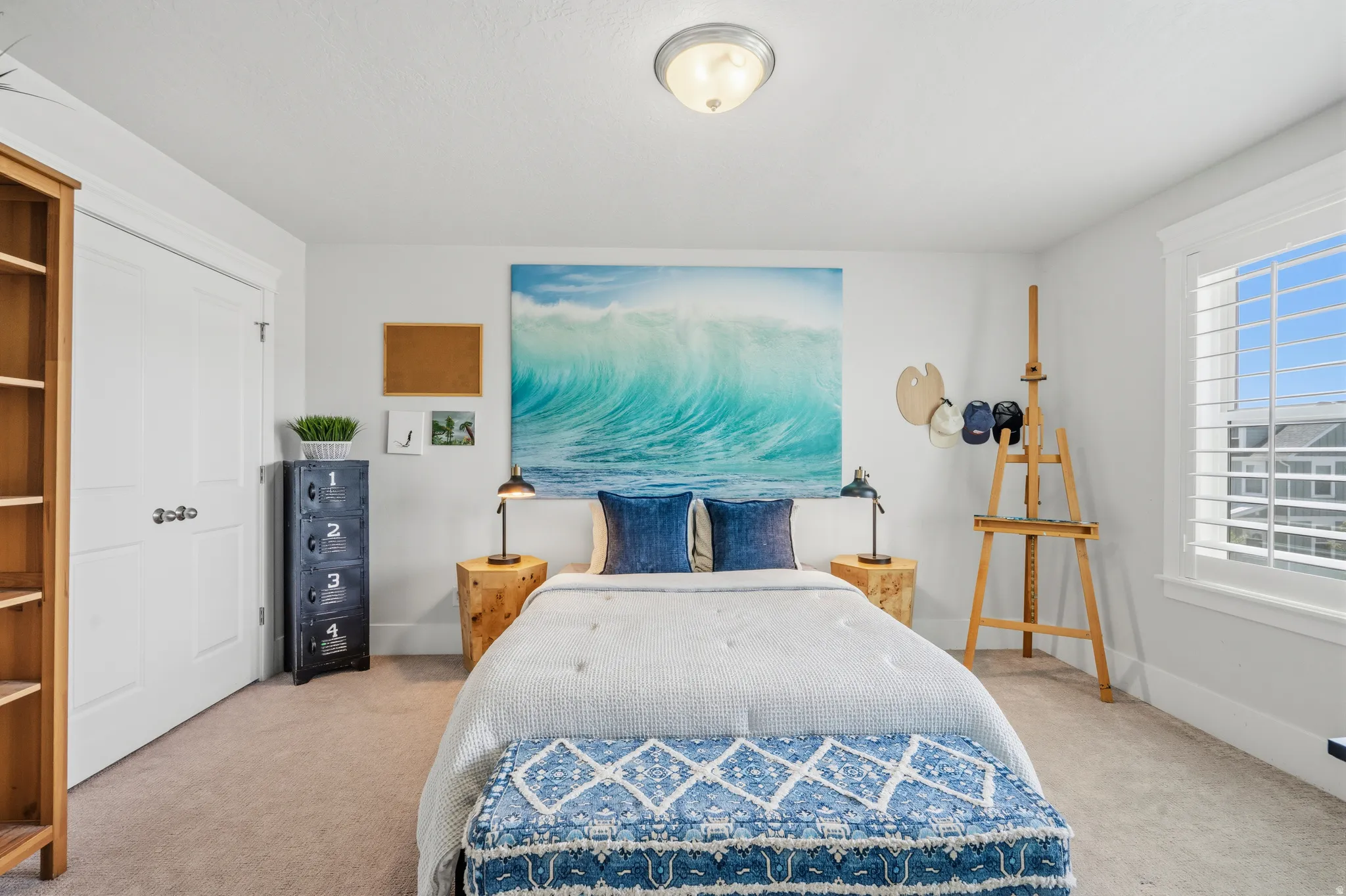 Bedroom featuring light gray walls, plush carpet flooring, a built-in closet with white bifold doors, a white window with plantation shutters, and a ceiling-mounted semi-flush light fixture