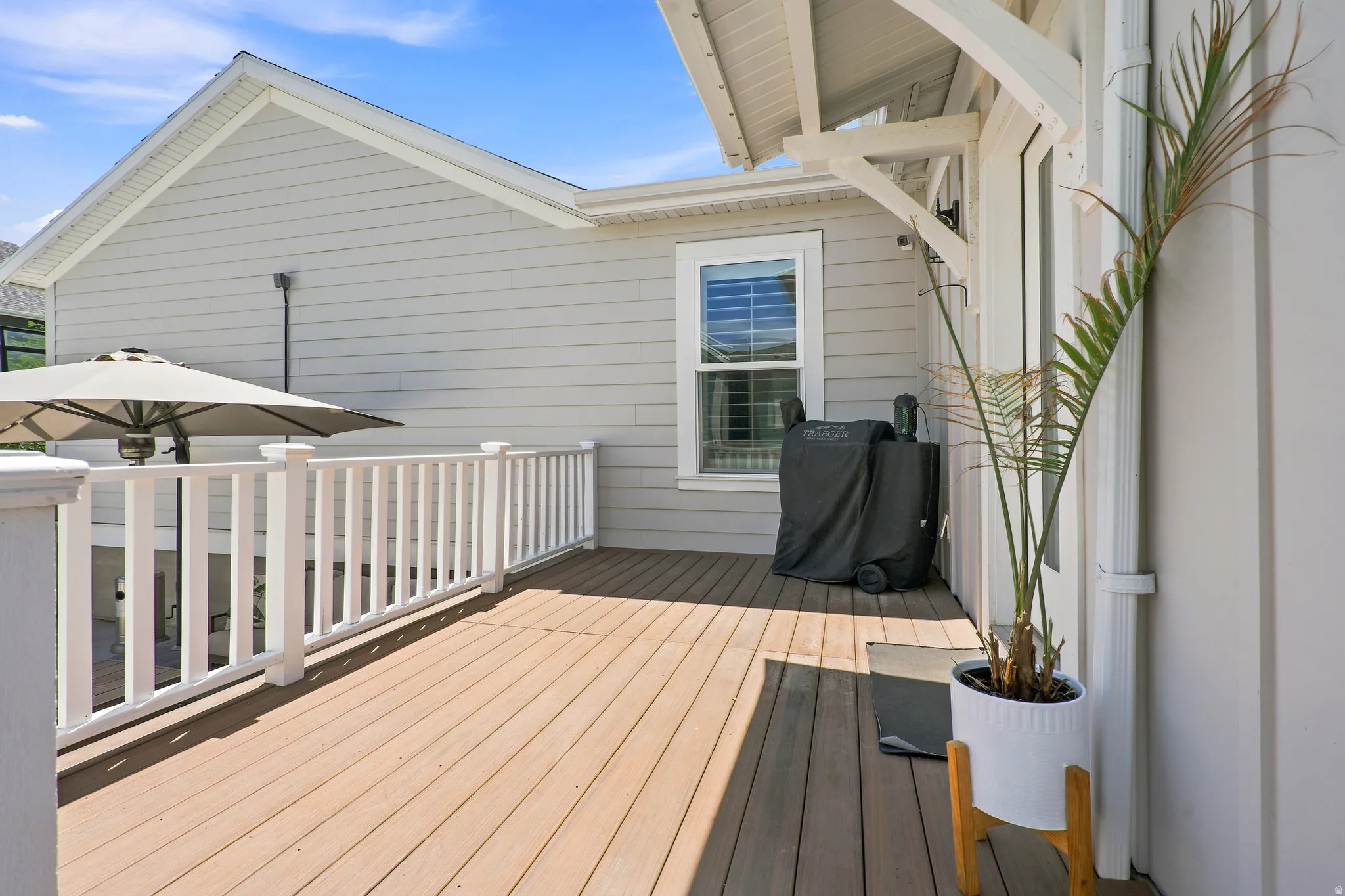Spacious outdoor deck featuring wood-finish flooring and white railing
