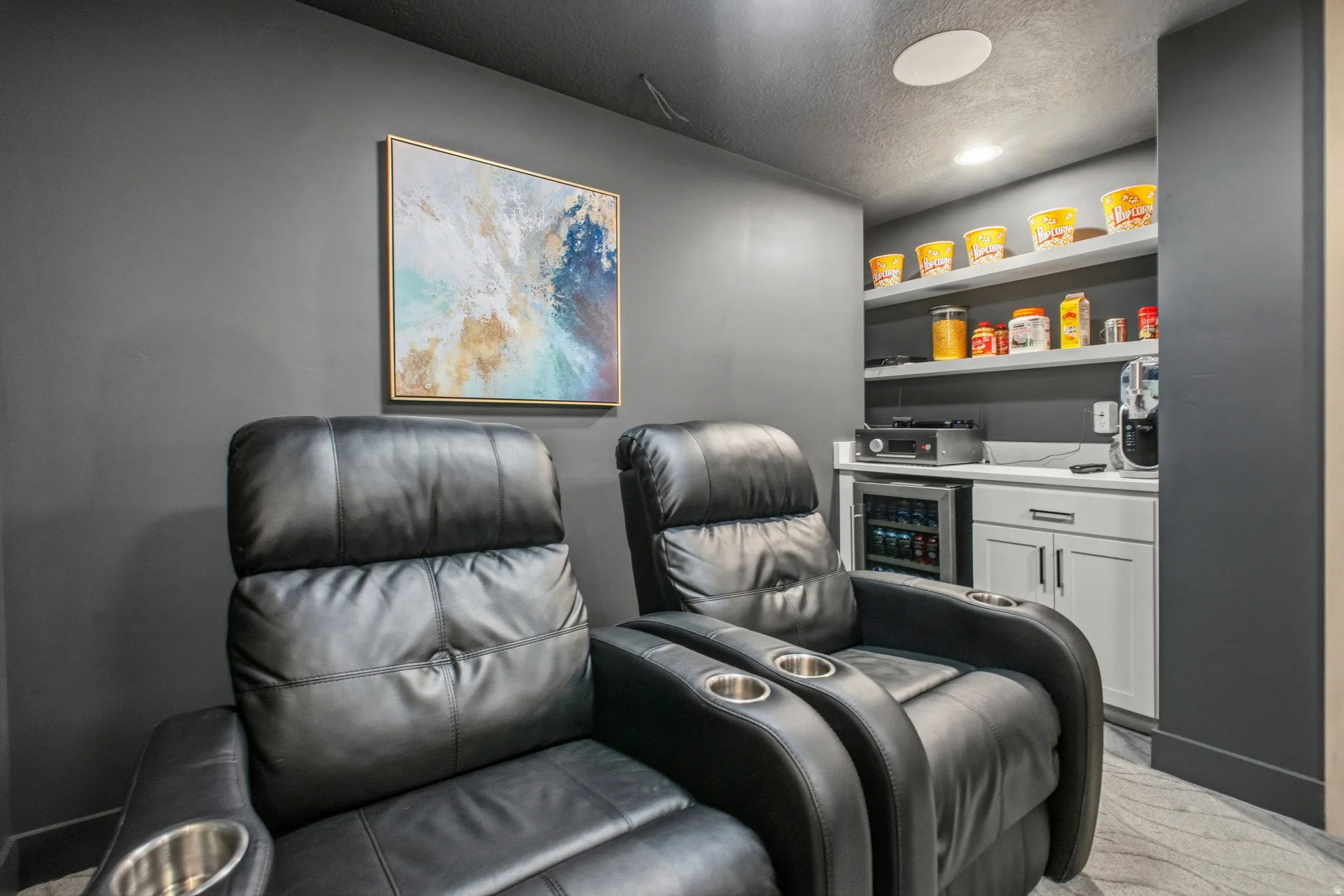 Custom entertainment space featuring black recliners with integrated cup holders