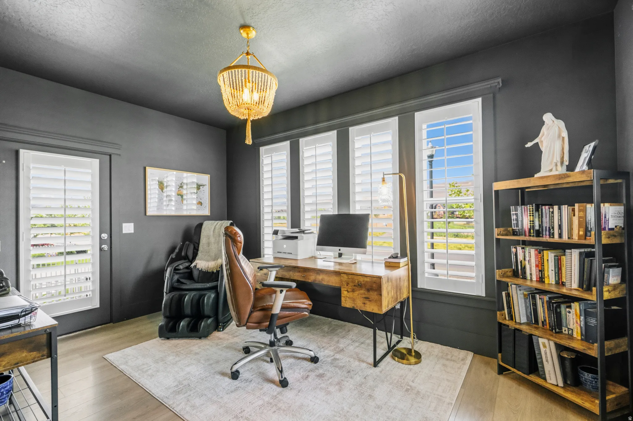 Dedicated workspace featuring light wood-finish flooring and a central area rug