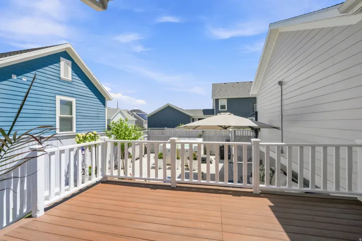 Expansive outdoor deck featuring wood-finish flooring and white perimeter railing