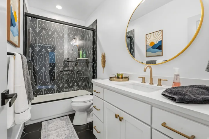 Bathroom featuring a white vanity with gold-tone hardware, a rectangular undermount sink, and a white countertop