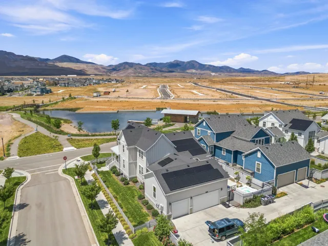 Modern residential development featuring a community lake and mountain backdrop