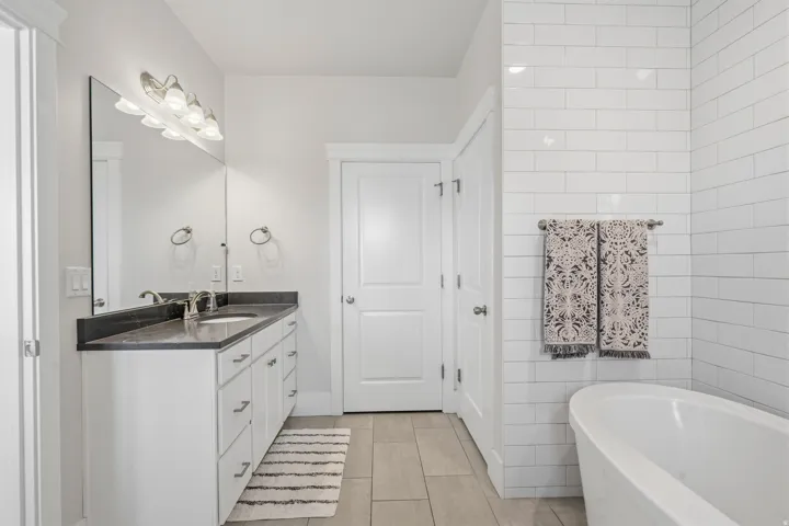 Bathroom with a freestanding soaking tub and white subway tile surround