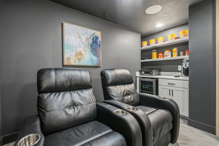 Custom entertainment space featuring black recliners with integrated cup holders
