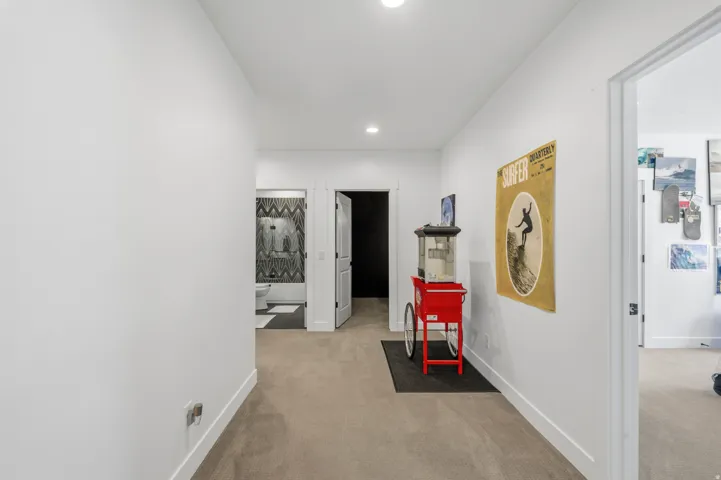 Interior hallway featuring recessed lighting, a neutral carpeted floor, and white baseboards