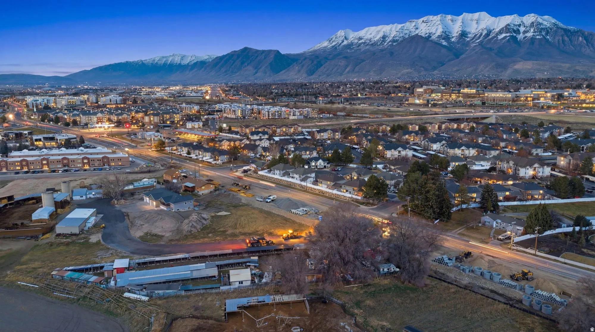 Expansive land parcel featuring multiple outbuildings, direct road frontage, and a mountain backdrop