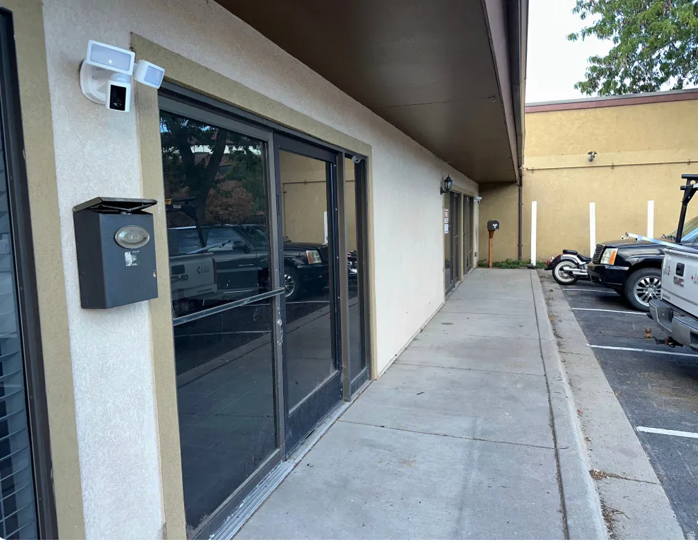 Storefront entrance featuring full-light glass doors and an extended concrete walkway