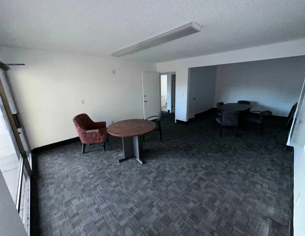 Spacious interior room featuring patterned carpet flooring and white painted walls