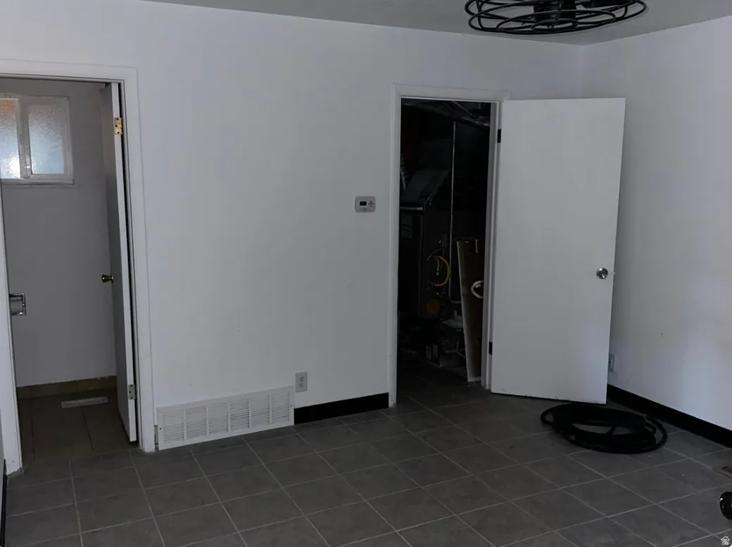 Interior space featuring tile flooring, white walls, and two doorways