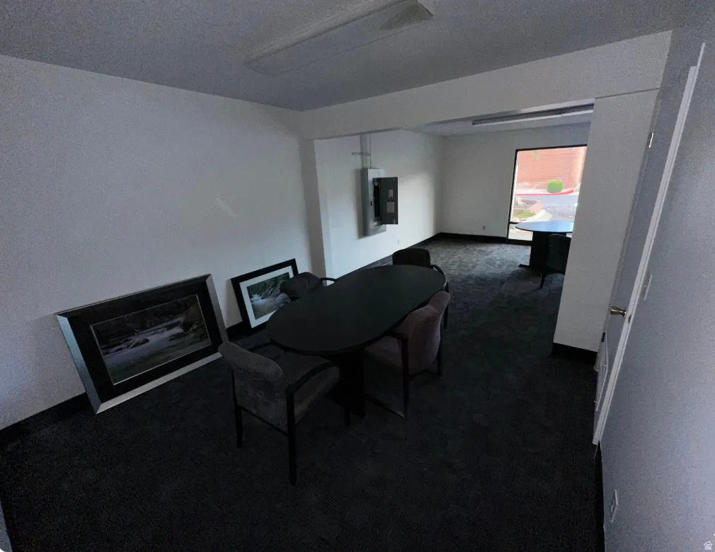 Spacious interior featuring dark carpeting, white walls, and a large window providing ample natural light