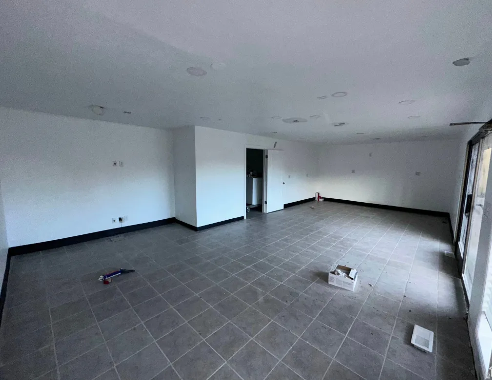 Spacious room featuring square tile flooring and white walls