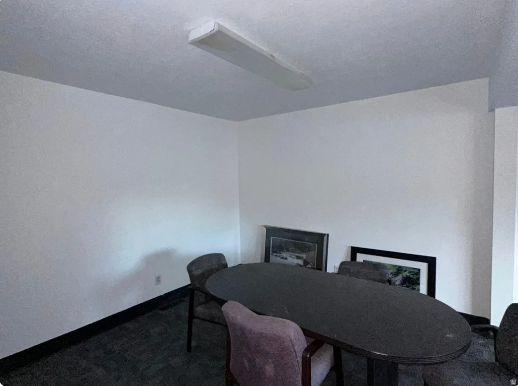 White painted walls with black baseboard trim, textured ceiling, and recessed fluorescent lighting