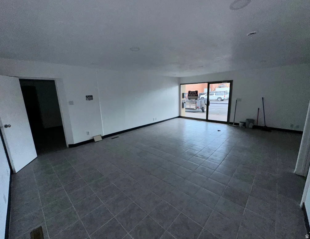 Spacious room featuring gray ceramic tile flooring and white walls