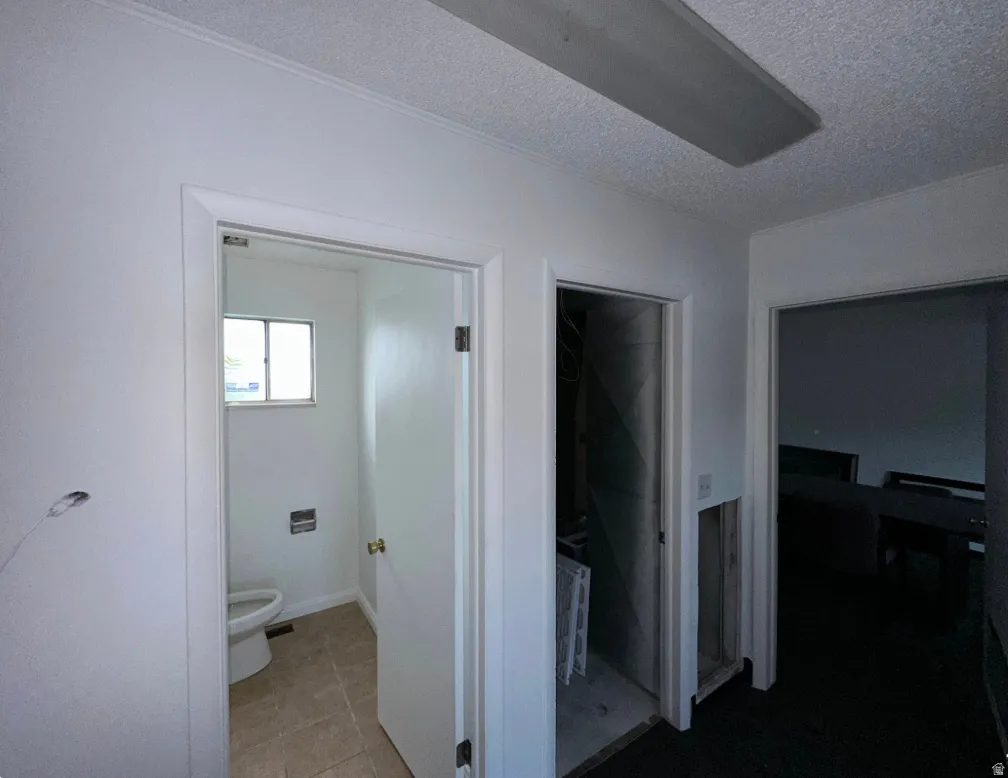 Interior hallway with multiple doorways and a visible light fixture