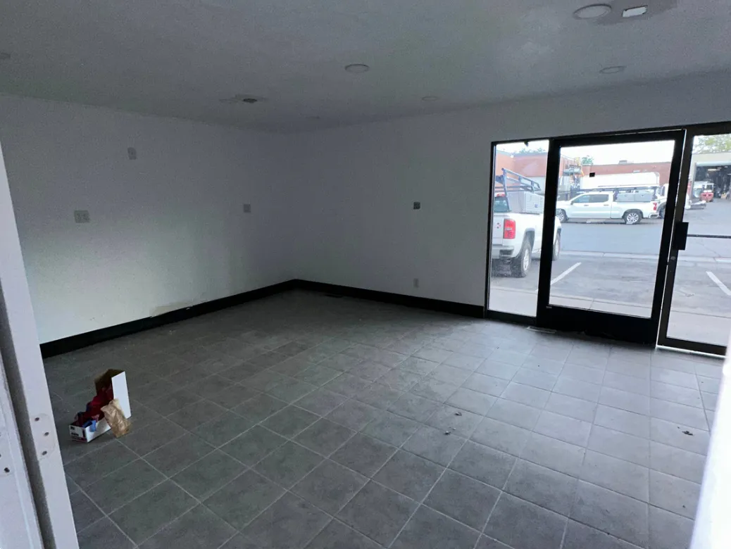 Spacious interior featuring a tiled floor, recessed lighting, white walls, and a large glass storefront
