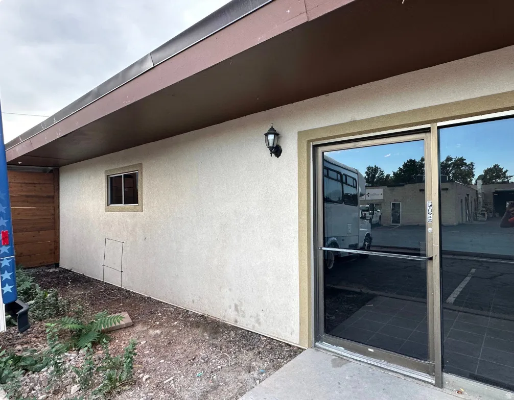 Commercial storefront entrance featuring a large glass door with a silver-tone frame