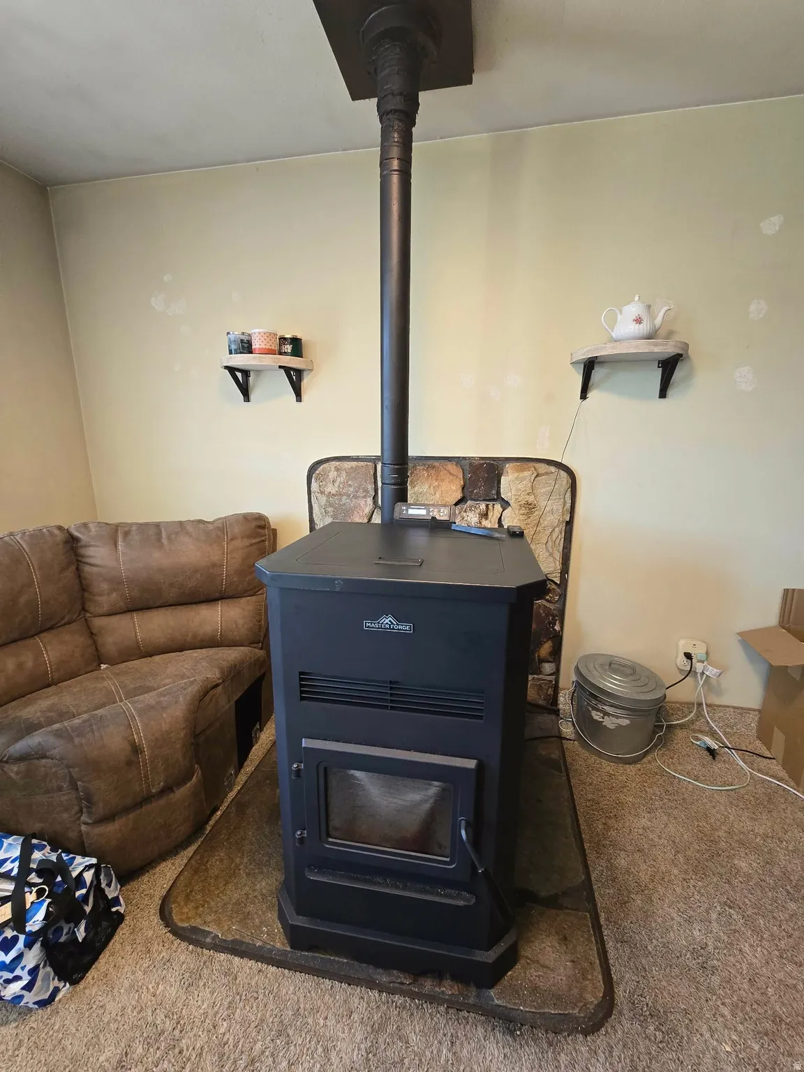 Freestanding black pellet stove with visible exhaust pipe extending to the ceiling