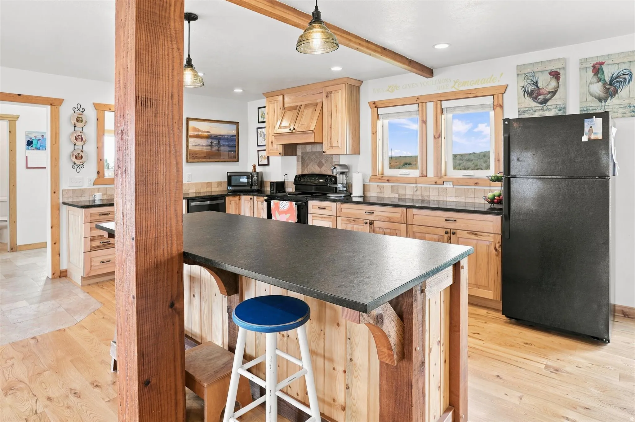 Kitchen featuring wood-finish cabinetry, dark countertops, and a central island with a breakfast bar