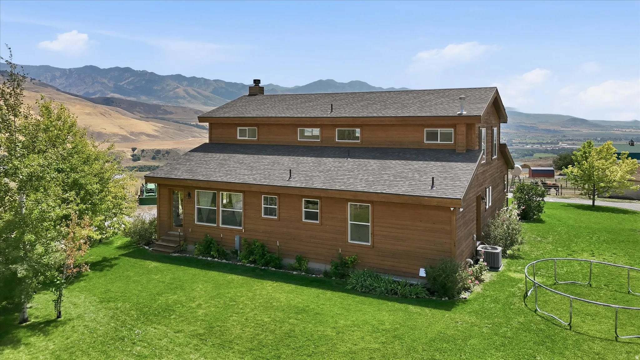 Multi-level property featuring wood-finish siding, a dark shingle roof, and a covered porch