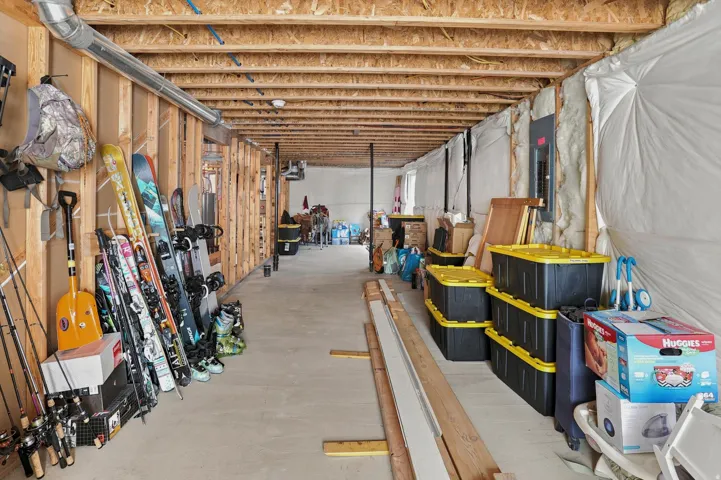 Unfinished basement featuring exposed wood joists and concrete flooring