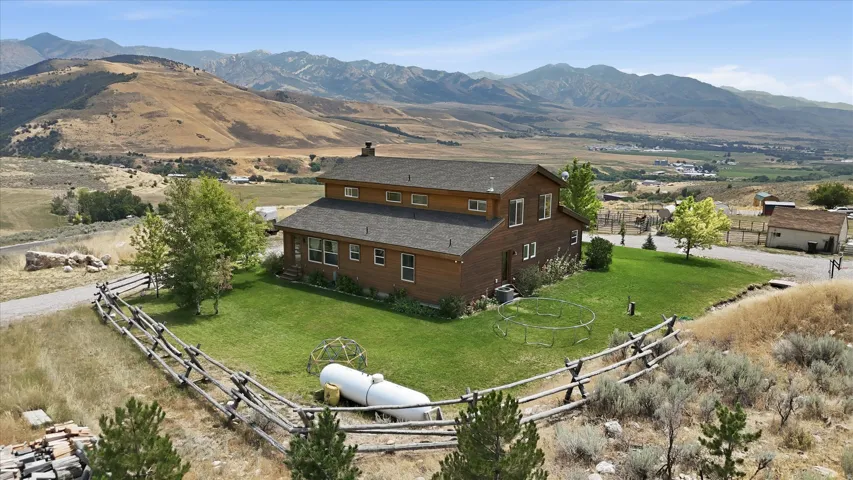 Two-story residence with wood-finish siding, a dark shingle roof, and multiple windows