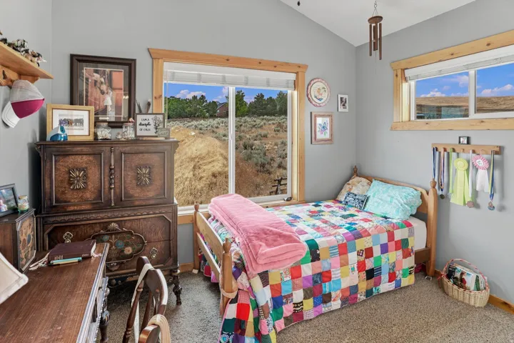 Room featuring light gray walls, natural wood trim, and a vaulted ceiling