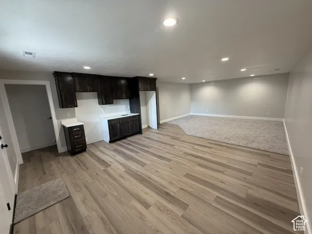 Wood-finish flooring leading to a carpeted area