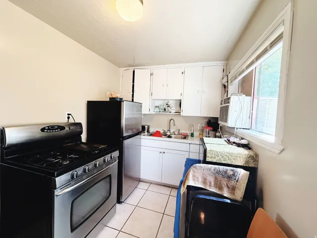 Kitchen featuring white cabinetry, a stainless steel range, and a stainless steel refrigerator