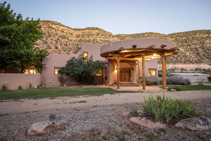 Adobe-style exterior with natural wood porte-cochere