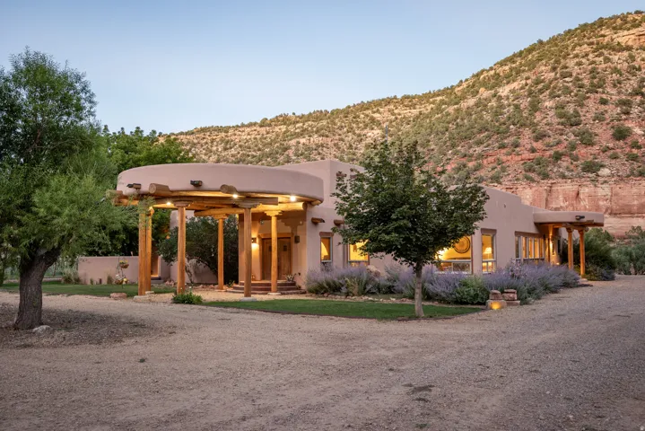 Southwestern-style residence featuring a stucco exterior, rounded architectural elements, and a covered entry with exposed wood beams