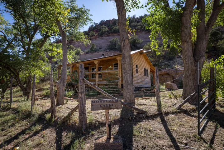 Rustic wood cabin featuring a covered porch with decorative columns