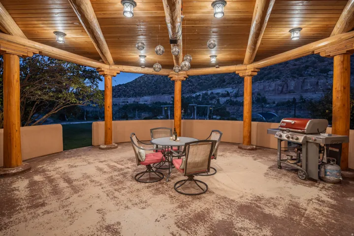 Covered outdoor patio featuring a wood-plank ceiling with exposed log beams