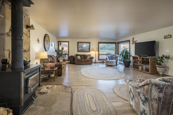 Living room with a stone-clad wood-burning stove and a flagstone hearth