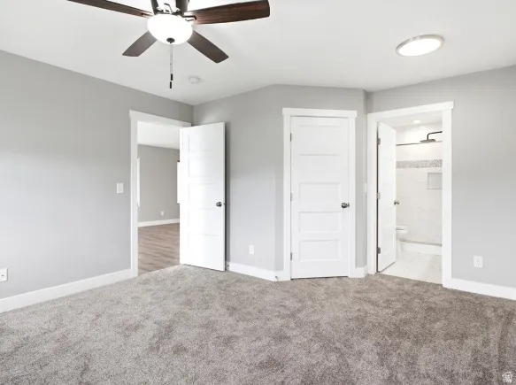 Spacious interior featuring neutral gray wall paint and plush gray carpeting