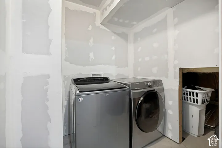 Utility space featuring drywall installation, electrical outlets, and a dedicated area for laundry appliances