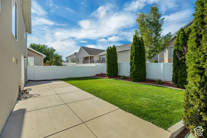 Private backyard featuring a well-maintained lawn and concrete patio
