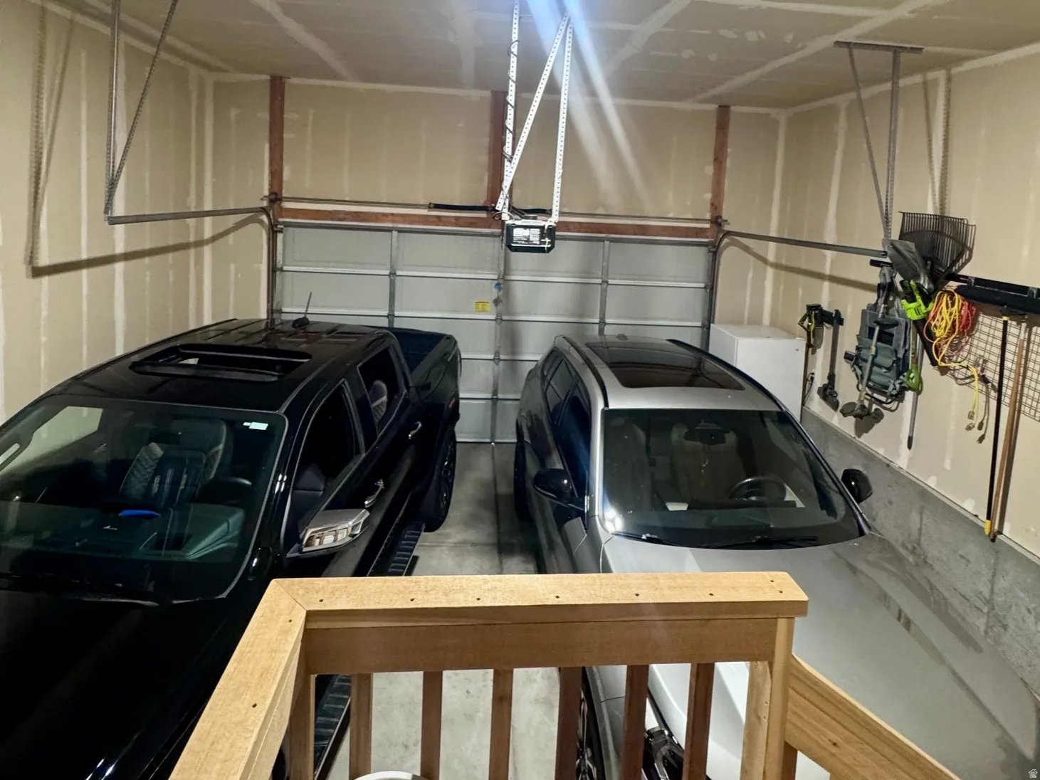 Two-car garage featuring a garage door, unfinished walls, and a built-in access panel