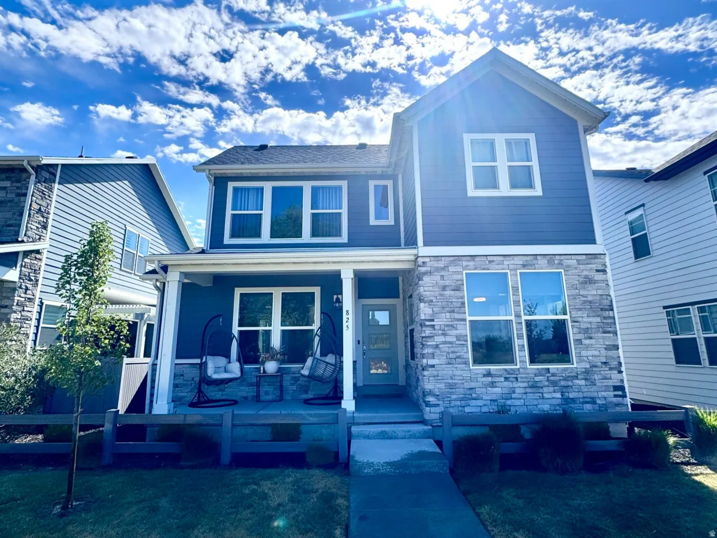 Modern two-story residence featuring a combination of blue horizontal siding and stone veneer