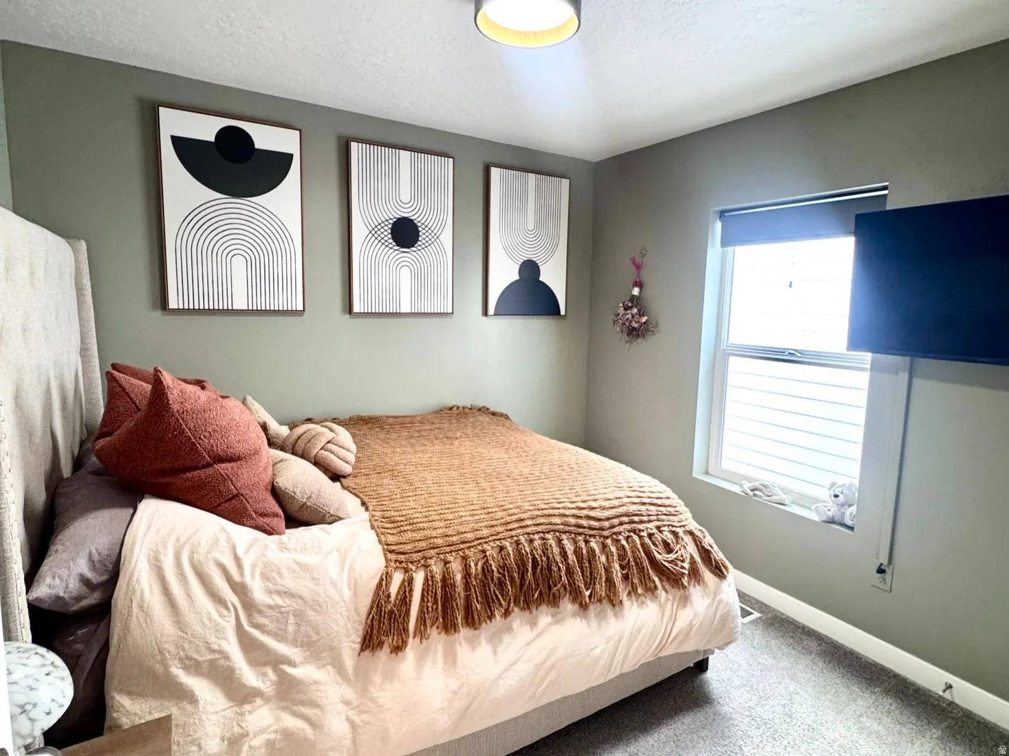Wall-to-wall carpeting and a single window with horizontal blinds