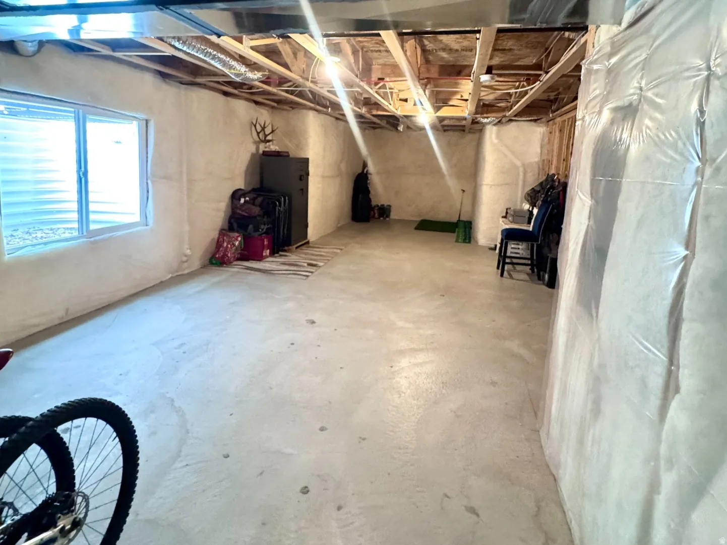 Unfinished basement offering substantial square footage, exposed ceiling joists, and a concrete floor